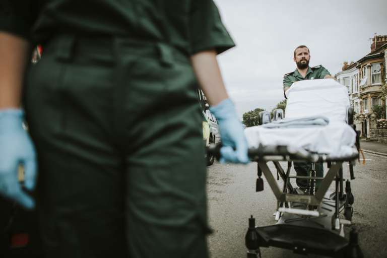 Paramedic team rolling a stretcher on a street