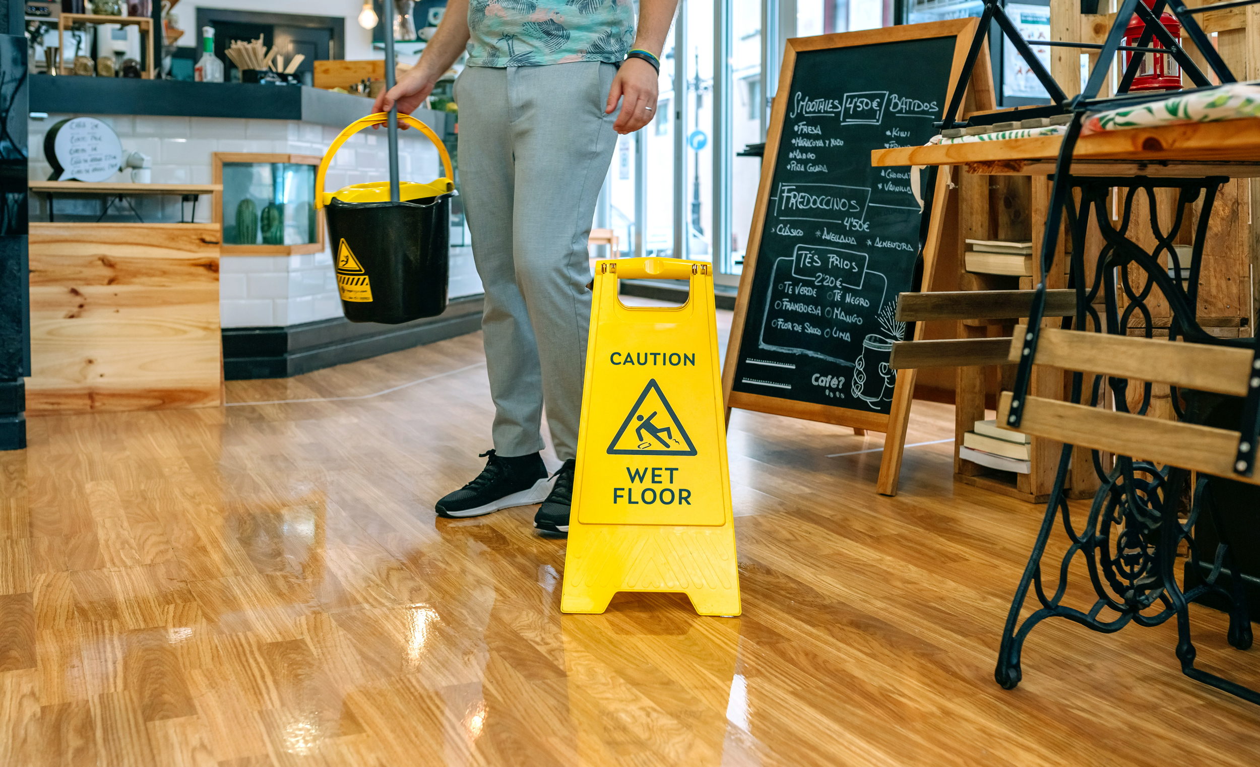 worker placing wet floor sign