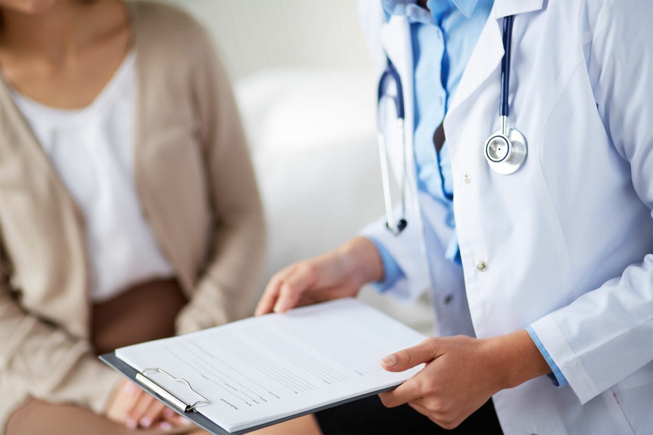 A photograph of a doctor holding a clipboard, in an article about the A&E four hour wait time, which might be scrapped