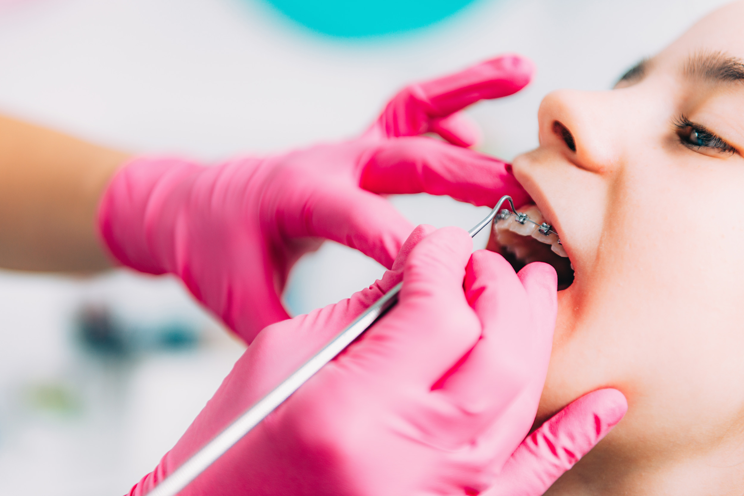 Orthodontist checking girl’s dental braces