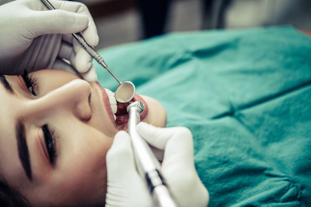 The dentist examines the patient's teeth.