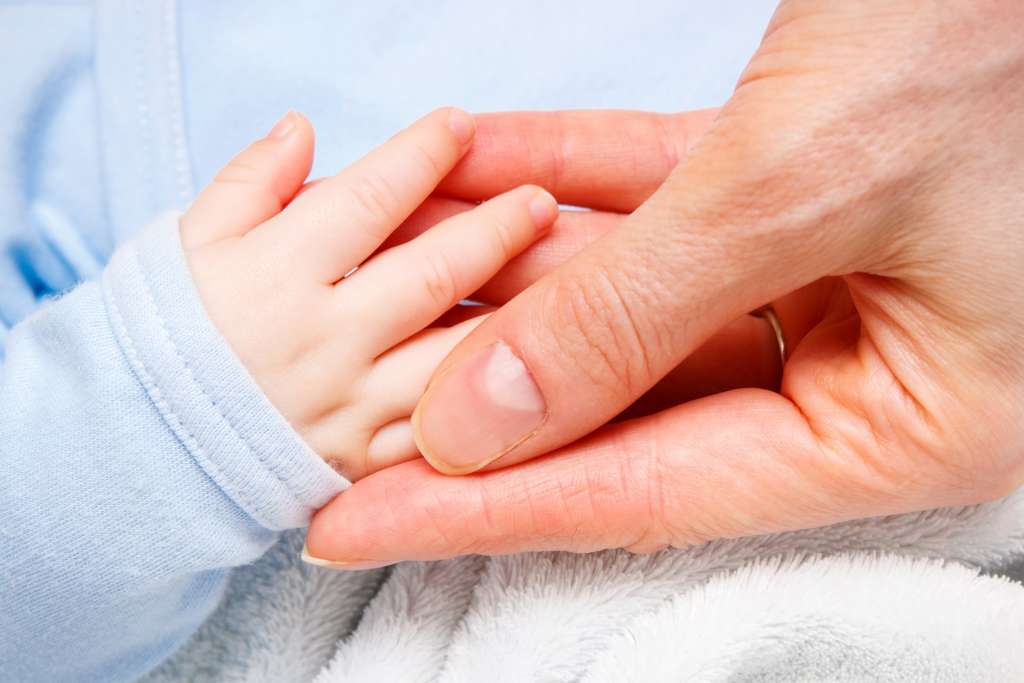 hand of newborn baby in hand of mother