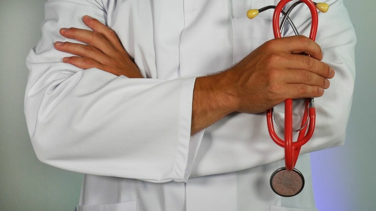 A photograph of a male, in a white top, holding a stethoscope, to depict a junior doctor.,