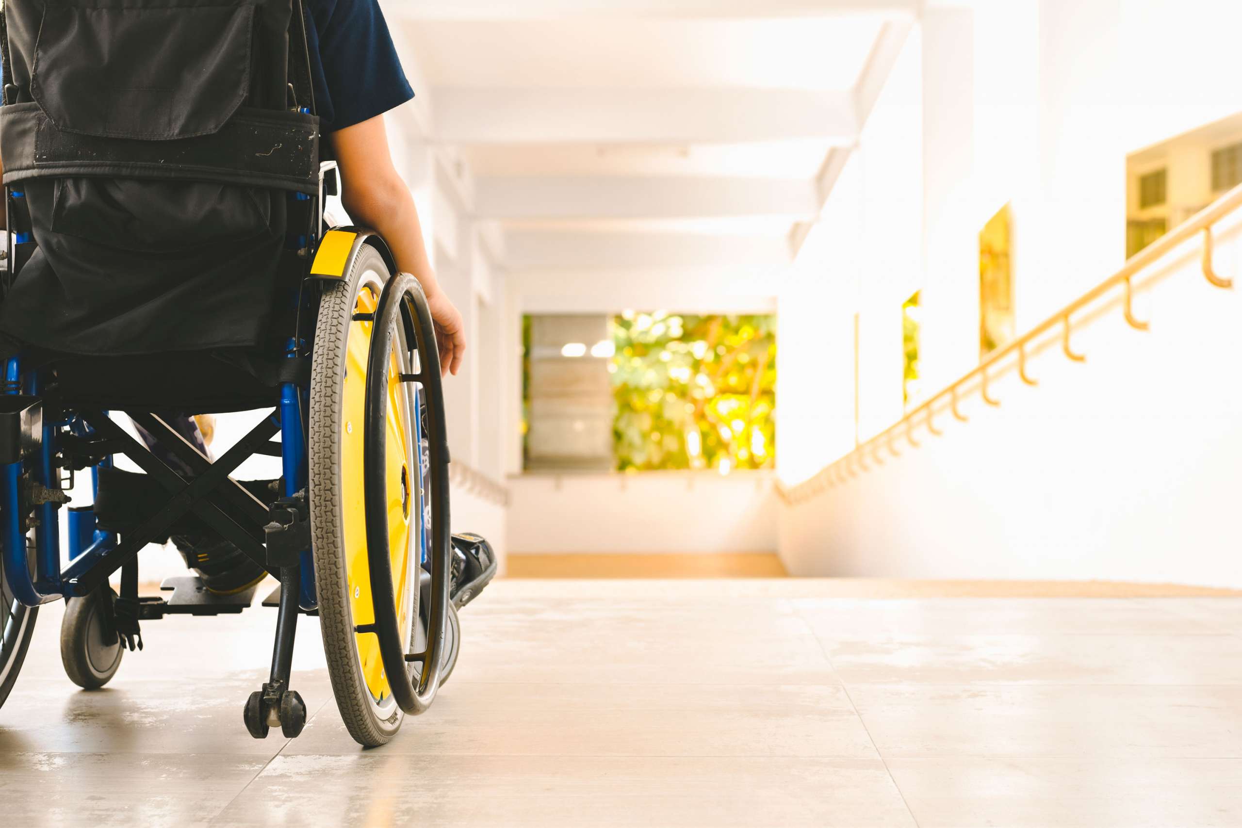 A photograph of a person in a wheelchair, taken from behind
