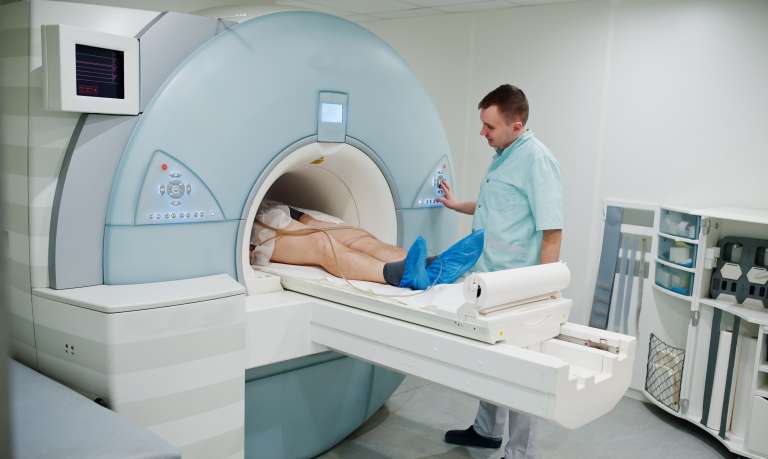 male doctor turns on magnetic resonance imaging