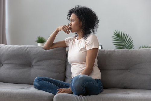 young woman looking off into the distance with a sad expression