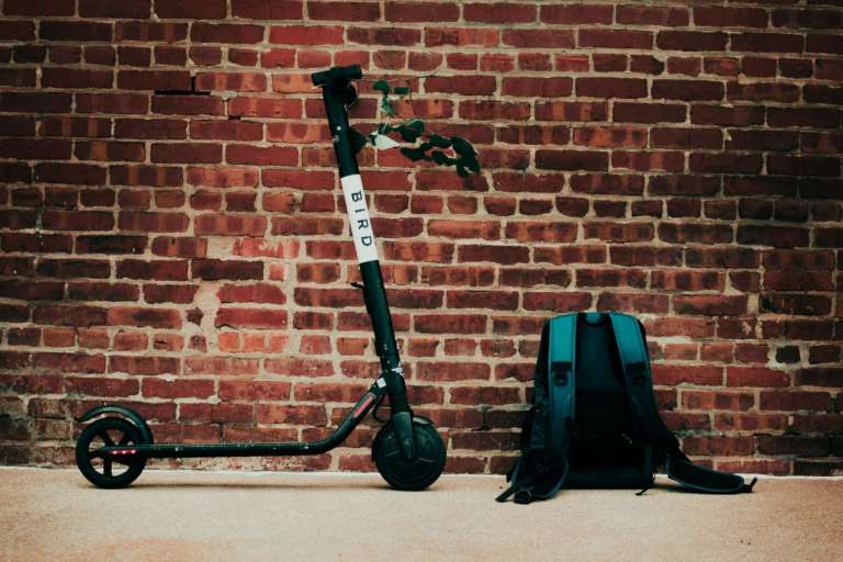 A photograph of an electric scooter (E-Scooter) against a wall. We questions whether the UK's roads are e-scooter friendly.