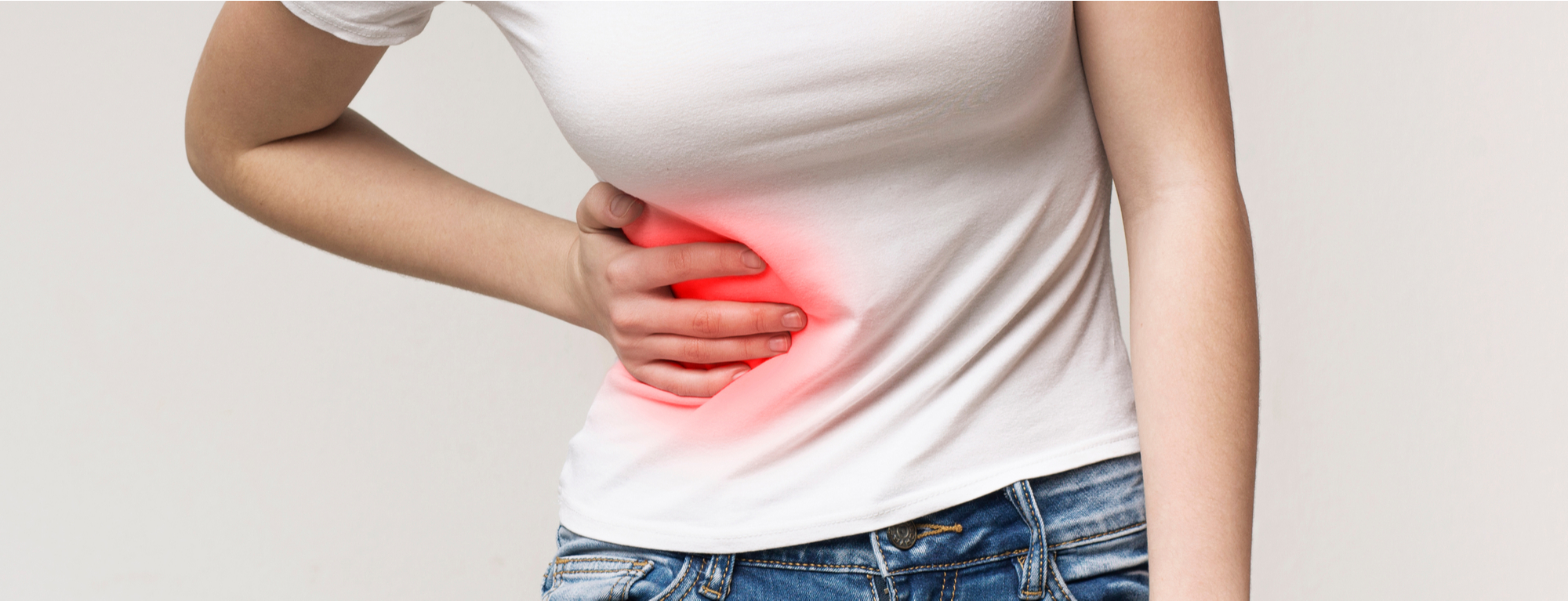 A photograph of a lady holding her stomach, where appendicitis might cause pain