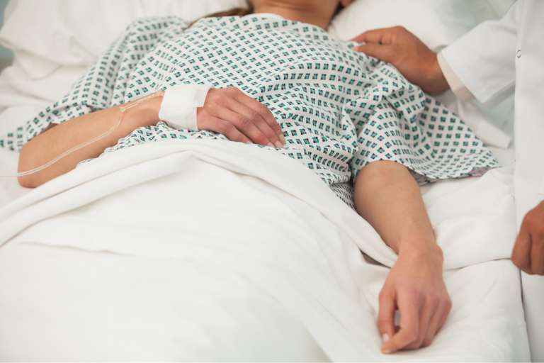 A photograph of a lady lying in a hospital bed