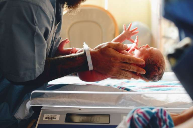 A photograph of a child after birth in hospital. NHS fees for migrants are putting babies, like this, and their mothers at risk.