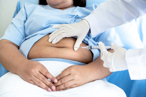 woman receiving stomach injection from doctor