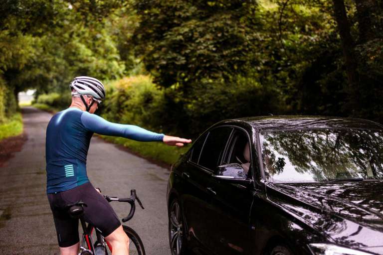 A cyclist converses with a driver.