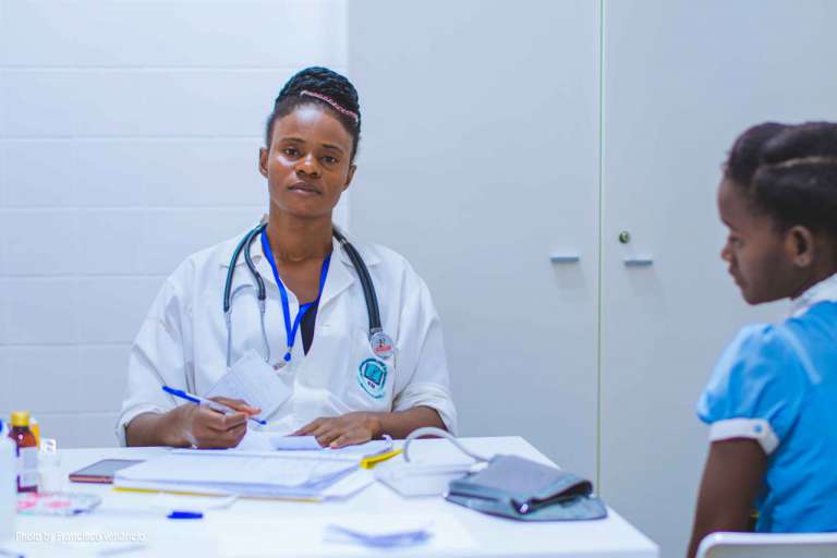 doctor sitting at table in front of girl