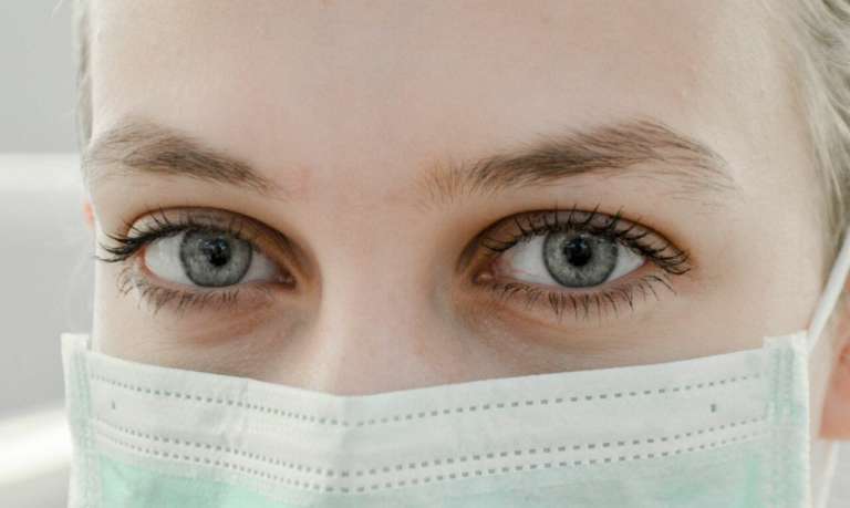 A nurse wearing a protective mask. These workers are some of those affected by NHS under-resourcing.