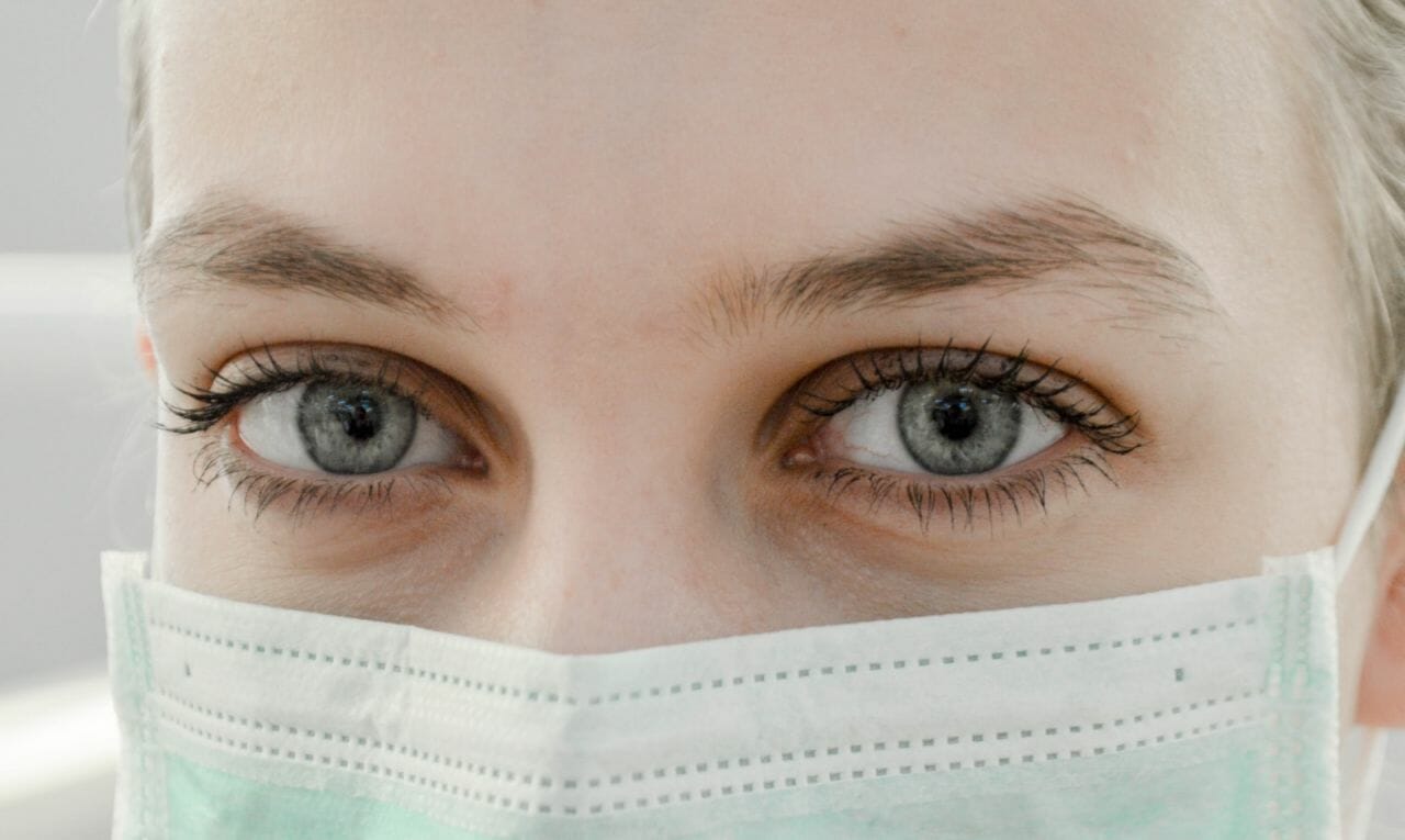 A nurse wearing a protective mask. These workers are some of those affected by NHS under-resourcing.