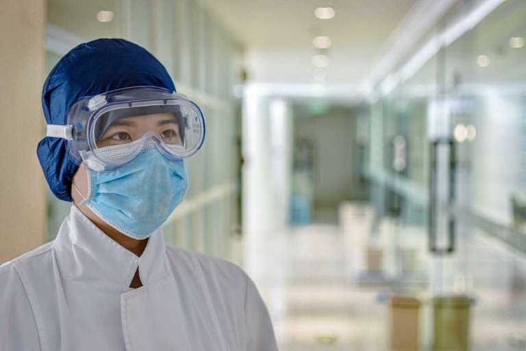 A photograph of a female medical professional wearing protective equipment, to depict the shortage of personal protective equipment for NHS staff.