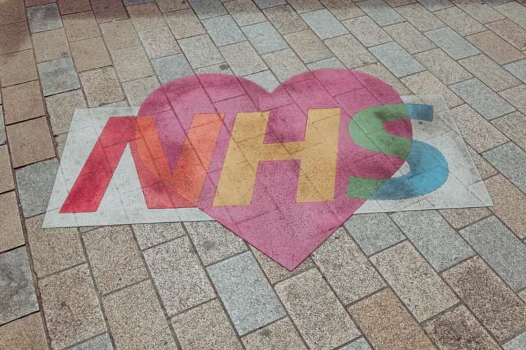 An image drawn on the pavement, in the UK, of the NHS logo with a heart - as a sign of appreciation, during the Coronavirus pandemic. Not long after, the Welsh government are accused of neglecting patients using the NHS.