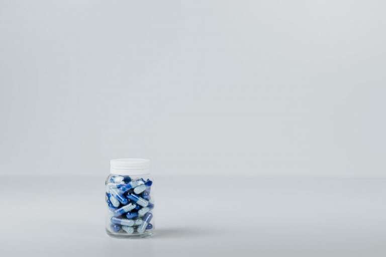 A photograph of blue medicine pills in a jar. The Cumberlege Review looked at issues arising from two medicines and a medical device.