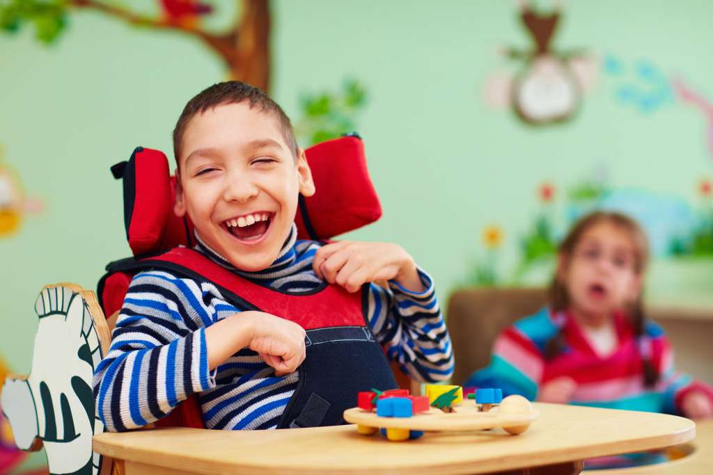 A photograph of a cheerful child, with cerebral palsy.