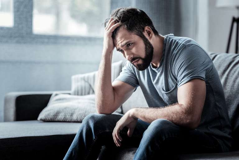 Man looking upset with head in hand