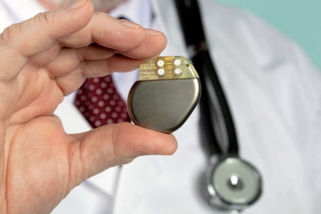 A photograph of a doctor holding a pacemaker.