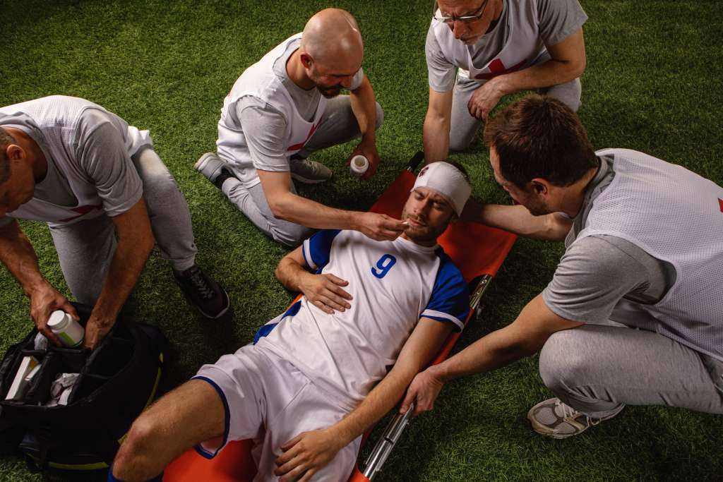 A photograph of a football player, with a head injury, on a stretcher